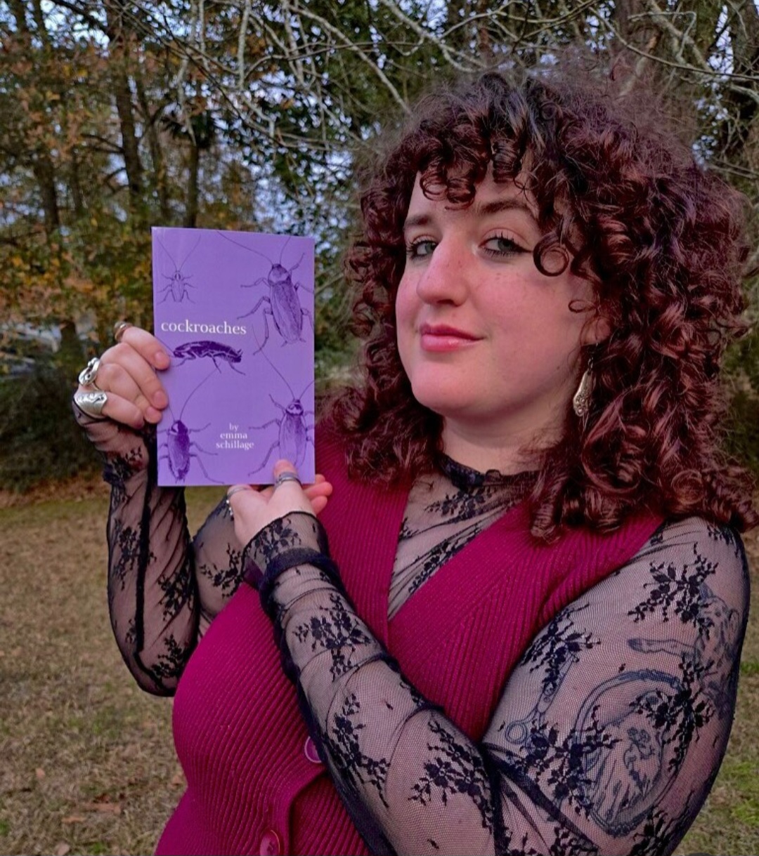A person with curly red hair holds a purple  script up to the camera